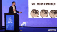 a man stands at a podium in front of a screen that says safemoon pumpingul