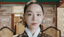 a woman in a traditional korean dress with a crown on her head .