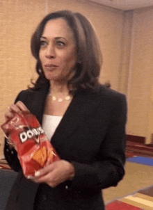 a woman holding a bag of doritos chips