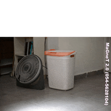 a fan sits next to a laundry basket with magnet 2.0 written on the bottom right