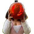 a woman is covering her face with a carved pumpkin