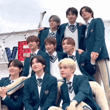 a group of young men in school uniforms pose for a picture in front of a sign that says love