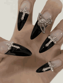 a close up of a person 's nails with crosses and rhinestones