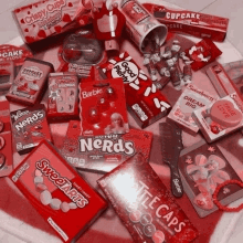 a variety of red candy including nerds and barbie