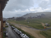 a row of cars are parked in a parking lot in front of a mountain