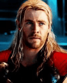 a close up of a man with long hair and a beard holding a hammer .