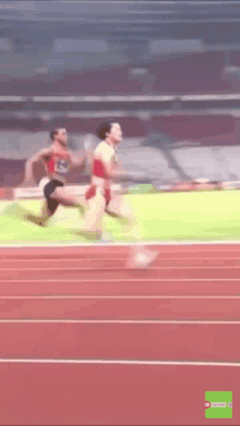 a blurred image of two runners on a track with a green screen behind them