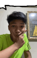 a young man making a funny face in front of a picture