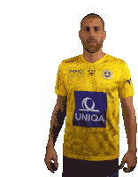 a man wearing a yellow shirt with immo united on the front