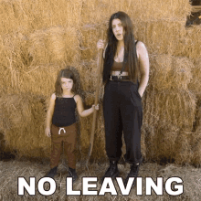 a woman and a little girl standing in front of a pile of hay with the words no leaving written below them