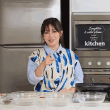 a woman is standing in front of a sign that says laughter and wild plans come together in this kitchen