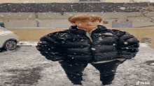 a person wearing a black north face jacket stands in the snow