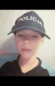 a young boy wears a blue hat that says policja