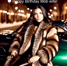 a woman in a fur coat is sitting in a green car with the words happy birthday mob wife below her