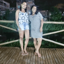 a woman in a polka dot top stands next to a woman in a striped dress