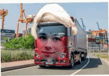 a red truck with a man 's face on the front is driving down a street .