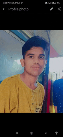 a young man in a yellow shirt is looking at the camera with the profile photo displayed