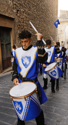 a man in a blue and white costume playing drums