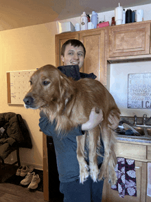 a man is holding a large dog in front of a sign that says " change things "