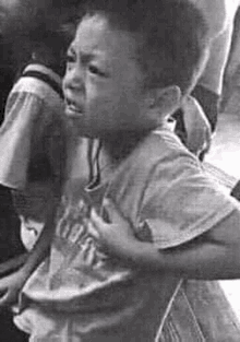 a young boy is crying in a black and white photo .