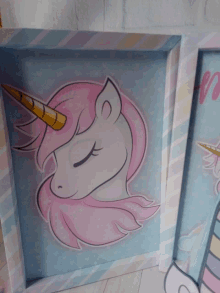 a framed picture of a unicorn with pink hair and a yellow horn