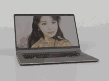 a laptop with a picture of a woman on the screen and the words soojin es mia