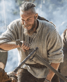 a man with a beard is holding a sword