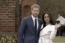 a man in a suit and tie and a woman in a white coat are standing next to each other .