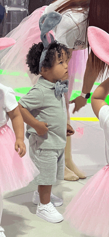 a little boy wearing bunny ears and white sneakers