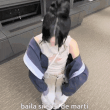 a girl in a blue jacket is squatting down with the words baila si eres de marti written on the bottom