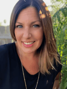 a woman wearing a black shirt is smiling for the camera