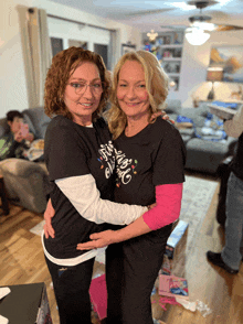 two women are hugging each other and one of them is wearing a t-shirt that says " i love you "