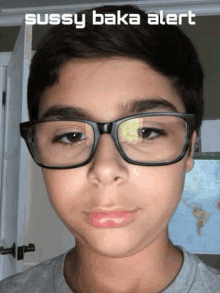 a young boy wearing glasses is standing in front of a door .