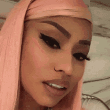 a close up of a woman 's face with a pink wig and a nose ring .