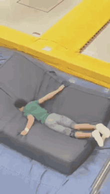 a person is laying on a trampoline with their arms outstretched .