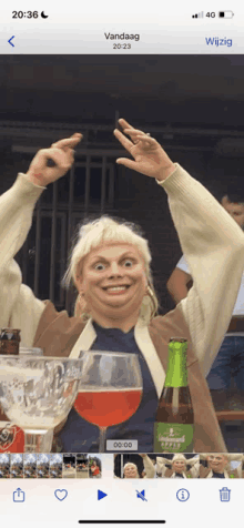 a phone screen shows a picture of a woman holding a glass of beer and a bottle of beer