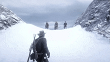 a group of men are standing on top of a snowy mountain .