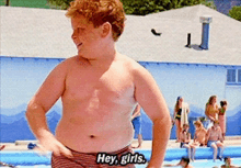 a shirtless boy stands in front of a swimming pool and says hey girls