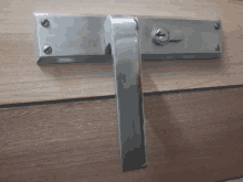 a stainless steel door handle with a key on a wooden wall