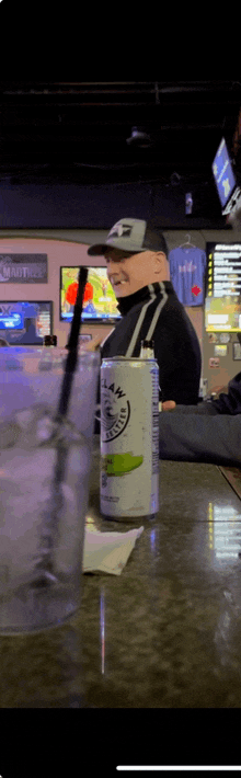 a man sits at a bar with a can of gatorade on the table