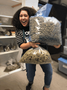 a woman is holding a bag of marijuana with the numbers 2 and 3 on it