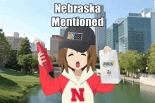 a girl in a nebraska mentioned sweatshirt holds a bottle and a bag