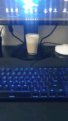 a cup of coffee sitting on top of a computer keyboard