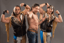 three wrestlers are posing for a picture and one has the word elite on his jacket