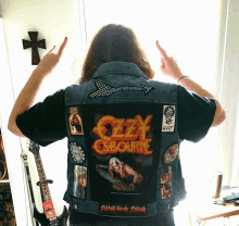 a man wearing a denim vest that says ' ozzy osbourne ' on the back