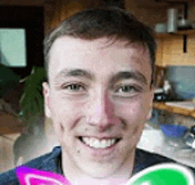 a young man is smiling while holding a candy in his hand .