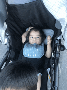 a baby in a stroller with a bib on his neck