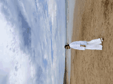 a person standing on a sandy beach with a cloudy sky in the background