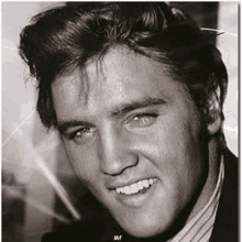 a black and white photo of elvis presley smiling and looking at the camera .