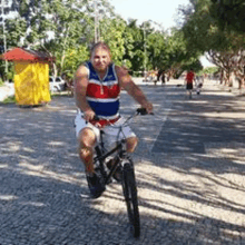 a man is riding a bicycle down a cobblestone street .